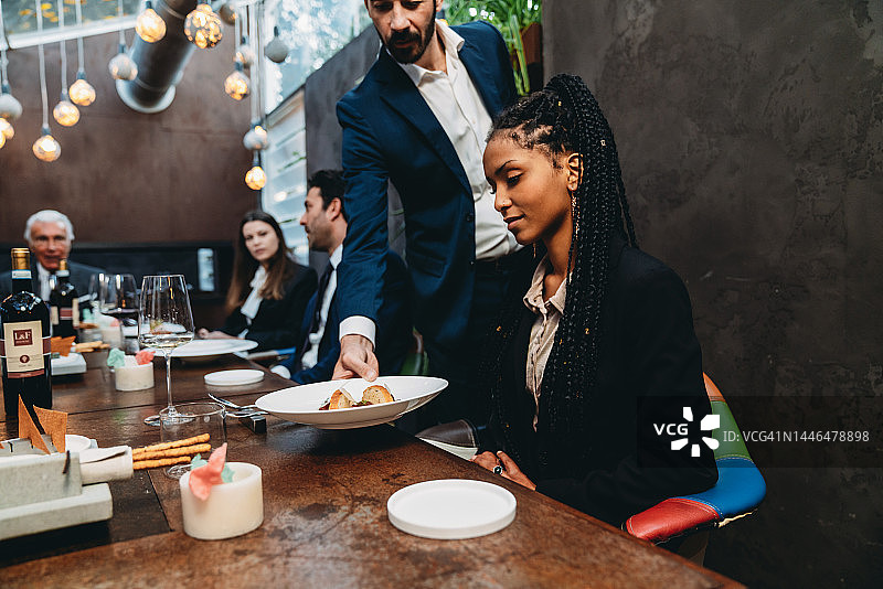 服务员在豪华餐厅为顾客上菜图片素材