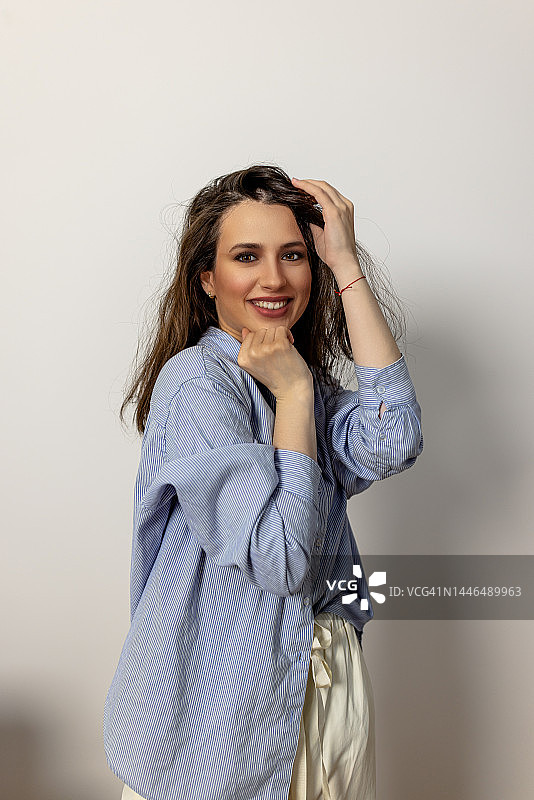 工作室白墙前的微笑时尚模特图片素材