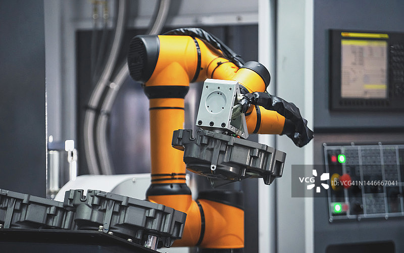 机器手臂在制造工厂中将零件输送到数控机床图片素材