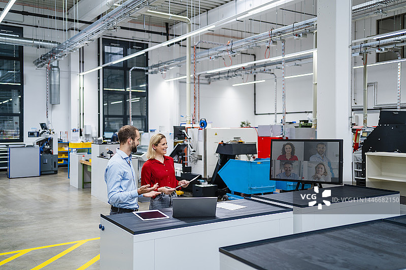 快乐的商业同事在工厂的电脑屏幕上进行视频通话图片素材