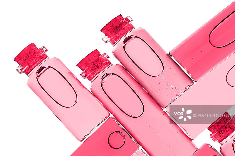 2023年度代表色万岁洋红色背景下的天然植物提取物实验室瓶图片素材