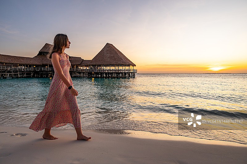 在坦桑尼亚Nungwi海滩享受日落漫步的女孩图片素材