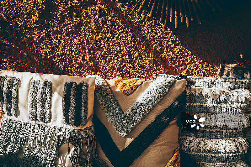 粗糙赤陶墙上的柔软马卡龙工艺枕头图片素材