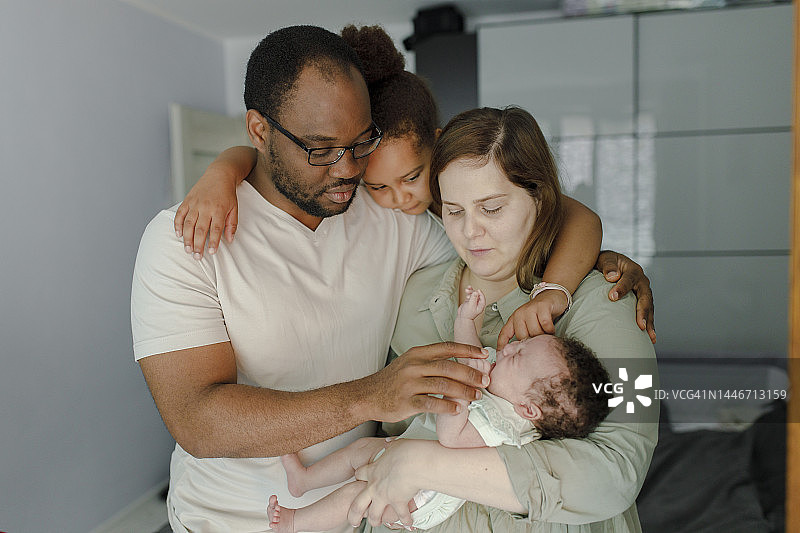 全家在家呵护哭泣的女婴图片素材