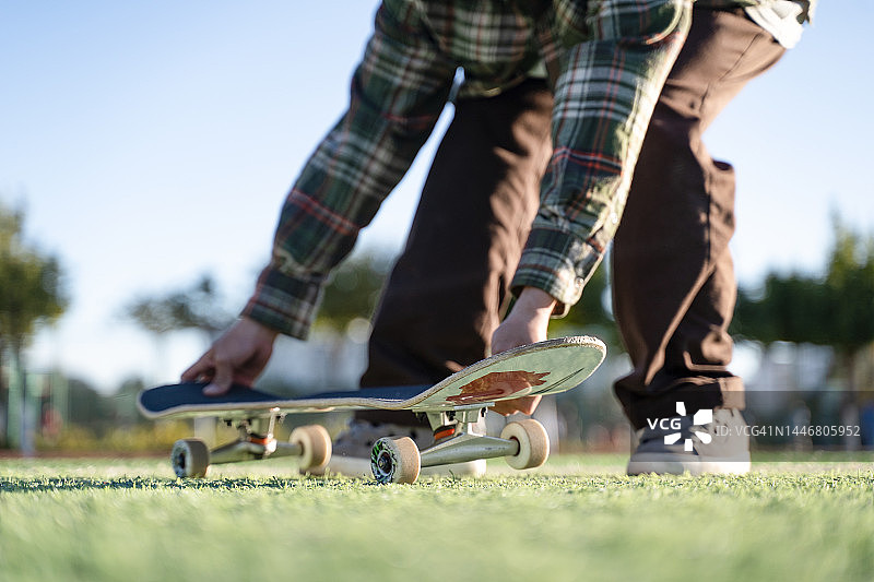 坐在草地上的滑板男孩图片素材