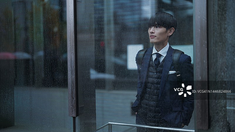 商人在城市里躲雨，寻找避免淋湿的地方图片素材