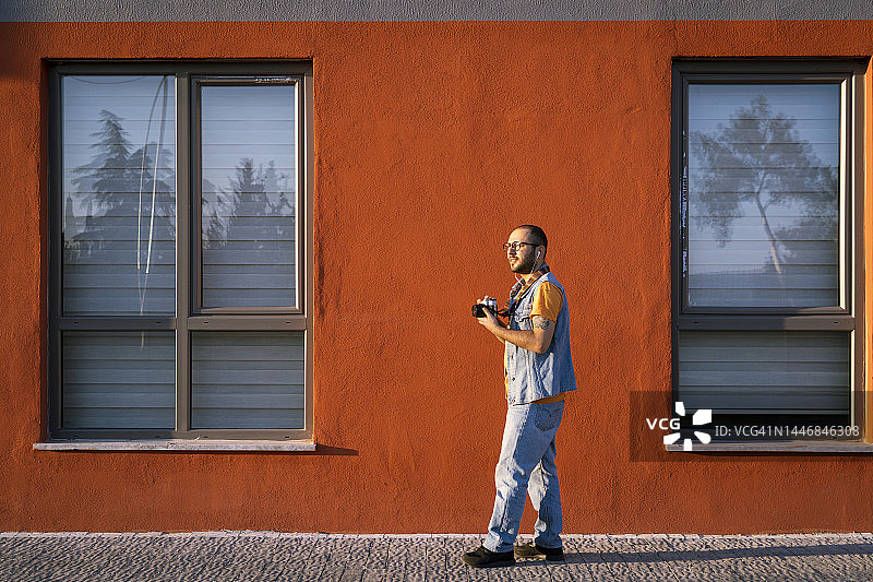 摄影师走过橙色墙壁图片素材