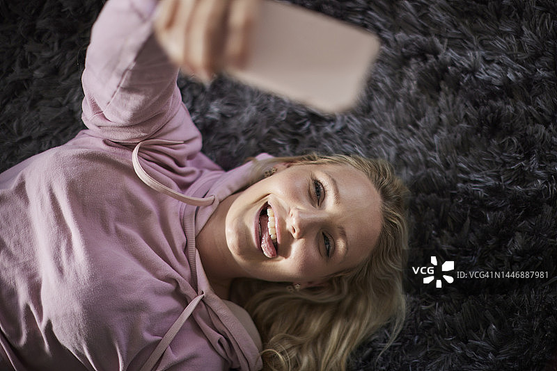 躺在地上自拍的年轻女子图片素材