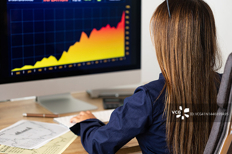 商人观看股票交易所信息，屏幕上显示上涨的股票图表图片素材