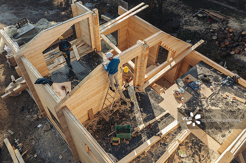 建筑工人们建造小木屋的鸟瞰图图片素材