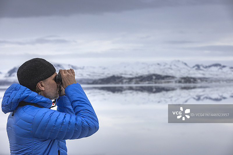 身穿冬装的白人男子眺望冰岛最大天然湖泊辛格瓦德拉湖图片素材