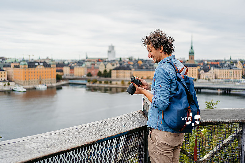 在高处拍摄斯德哥尔摩老城的年轻男人图片素材