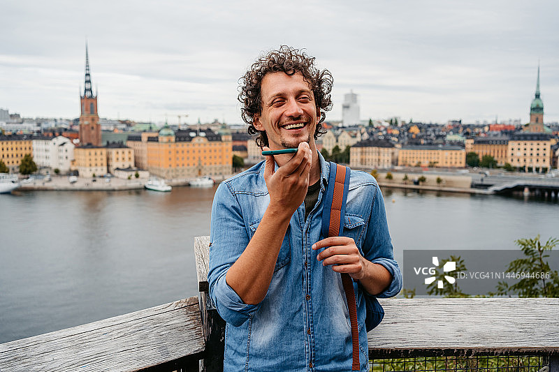 年轻男人在斯德哥尔摩的高处发送语音消息图片素材