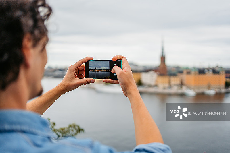 在高处拍摄斯德哥尔摩老城的年轻男人图片素材