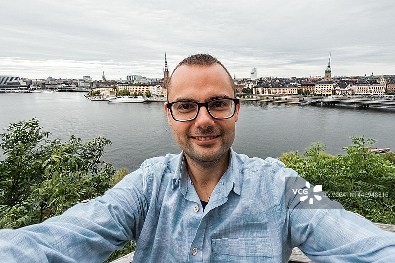 年轻男人在斯德哥尔摩码头自拍图片素材