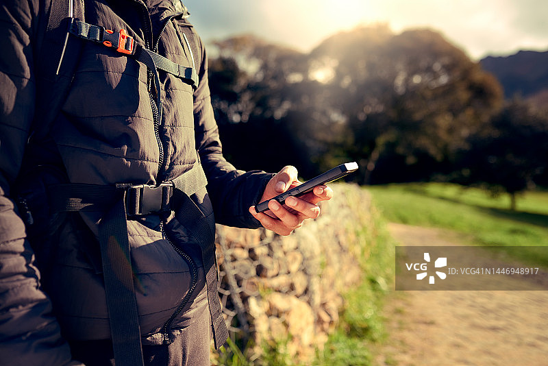 徒步旅行：自然和手，拿着手机使用GPS或在线地图应用程序上的位置，同时在意大利徒步旅行或步行。健身、缩放和徒步旅行者在树林或森林公园打字、聊天或搜索方向图片素材