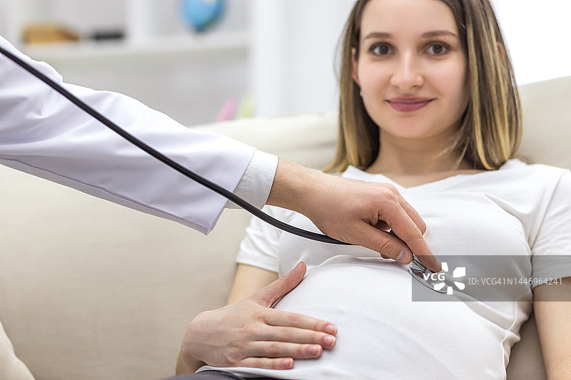 医生用听诊器检查孕妇特写图片素材