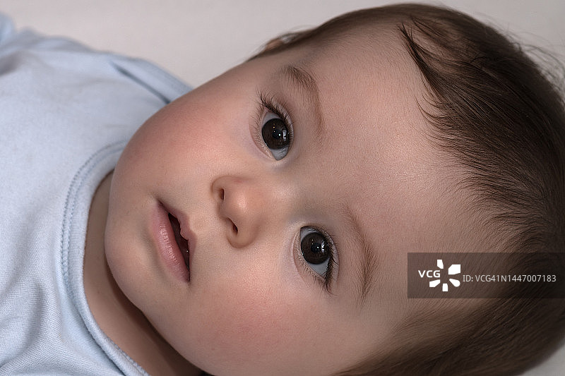 一岁左右的婴儿躺在那里凝视图片素材