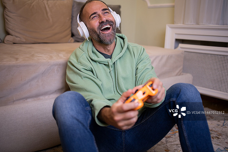 在客厅里玩电子游戏的男人图片素材