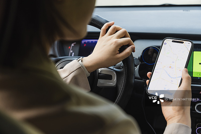 在车内用智能手机GPS导航的女子肩部视角图片素材