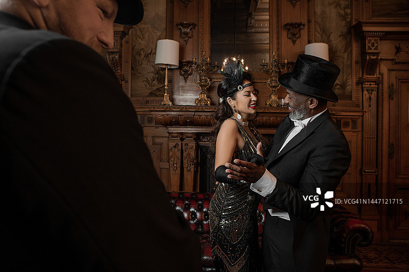 在棕色酒吧里穿着1920年代风格服装的混血情侣图片素材