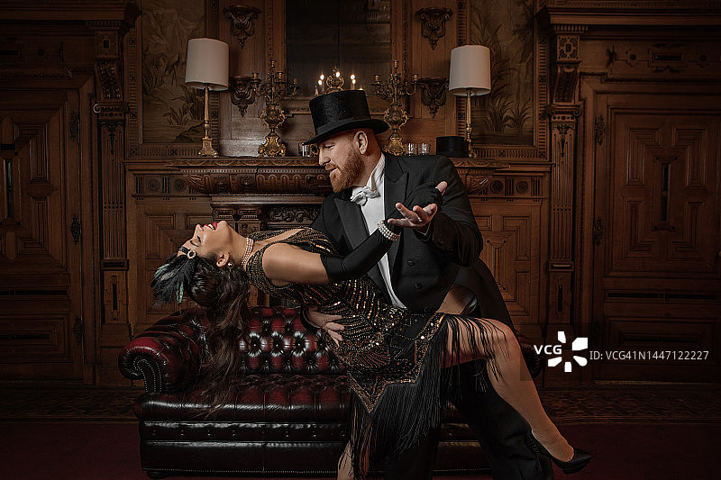 在棕色酒吧里跳舞的20世纪20年代风格的漂亮棕发红发夫妇图片素材