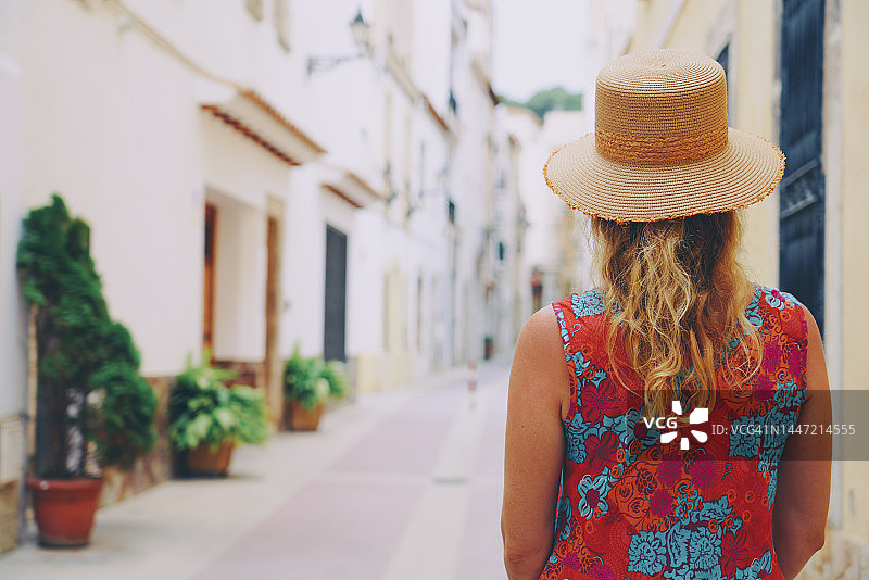 在西班牙加泰罗尼亚布拉瓦海岸托萨德马尔的街道上行走的一名女子图片素材