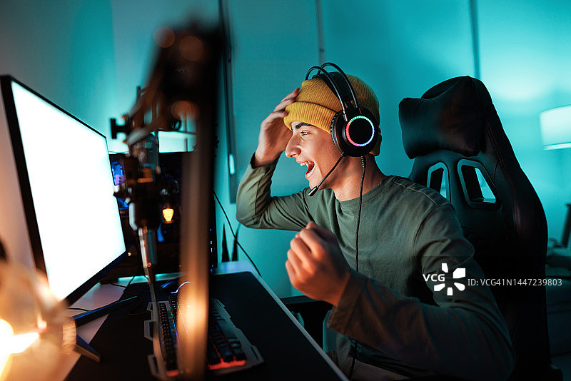 青少年玩电脑游戏并庆祝胜利图片素材