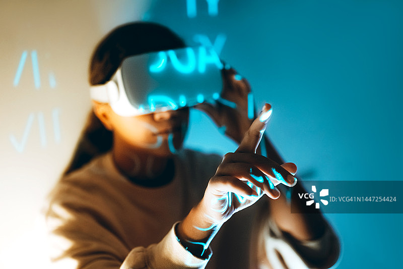 使用VR眼镜访问元宇宙世界的现代非裔美国女性图片素材