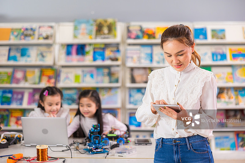 女教师在教室里使用平板电脑图片素材