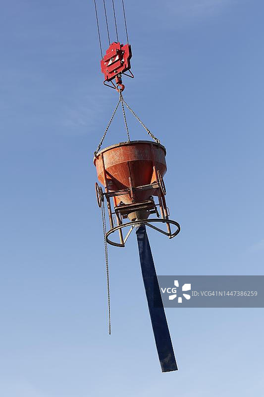 起重机悬挂的带软管的混凝土桶，大型建筑工地，德国北莱茵-威斯特法伦州杜塞尔多夫图片素材