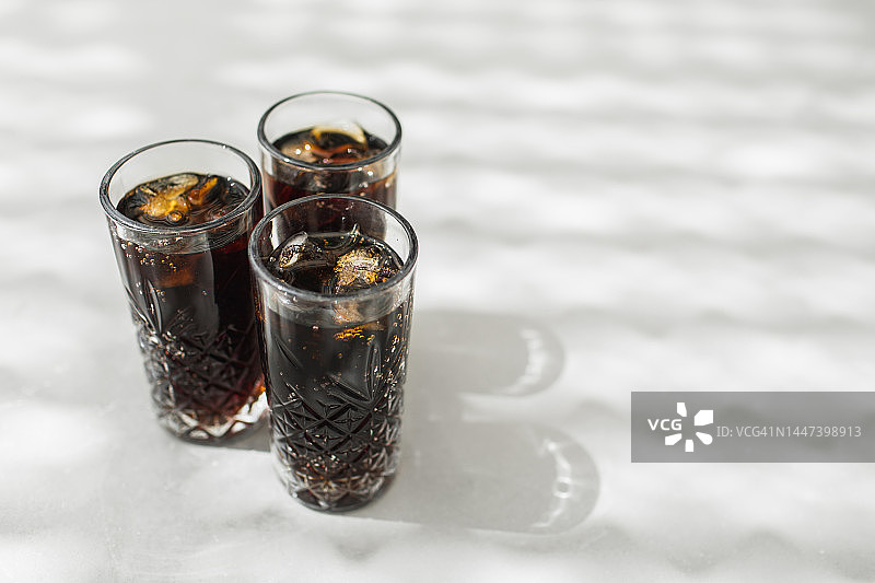 灰色背景下的冰镇可乐与冰块图片素材