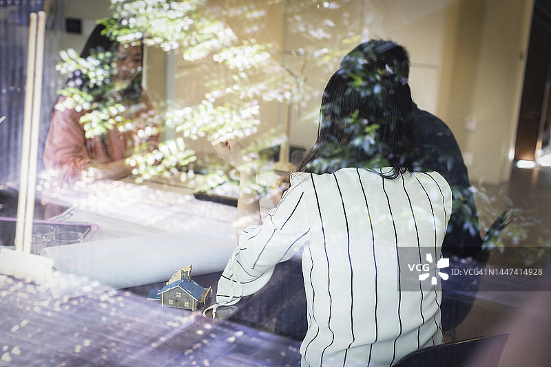 建筑师在会议室窗边开会图片素材