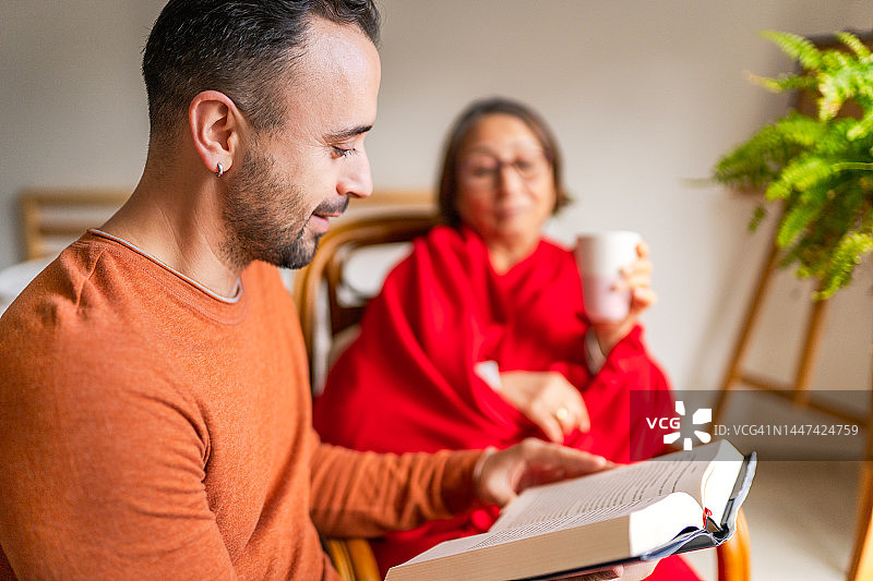 志愿者帮助年长妇女读书图片素材