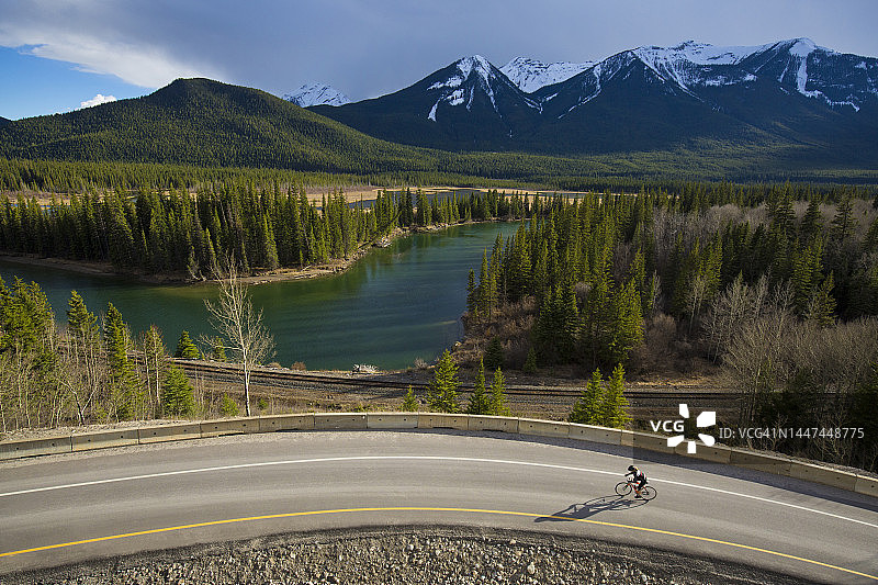 女子在班夫国家公园的弓谷公园大道上骑公路自行车图片素材
