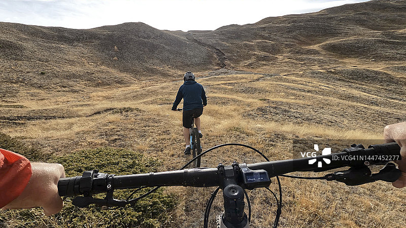 在高山小径上骑电动山地车的第一人称视角图片素材