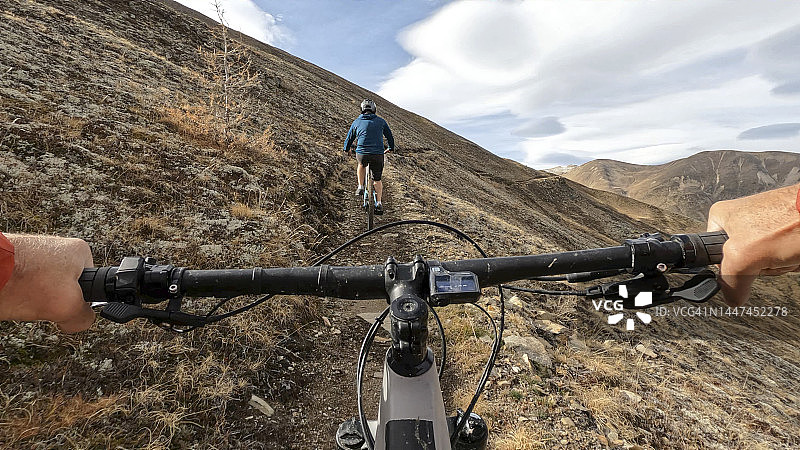 在高山小径上骑电动山地车的第一人称视角图片素材