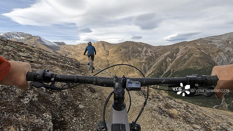 在高山小径上骑电动山地车的第一人称视角图片素材