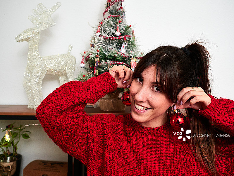 戴着圣诞球耳环的年轻白人女性肖像图片素材