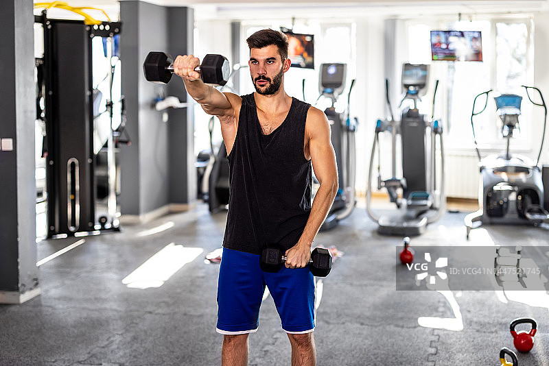 在健身房里做运动的年轻帅气男人图片素材