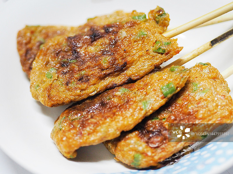 烤鱼饼，白盘中烤鱼串图片素材