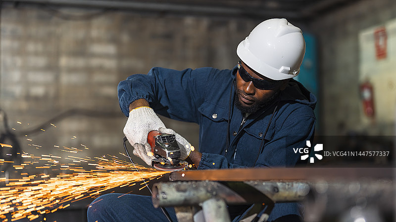 在工厂车间研磨金属零件的非洲工人图片素材