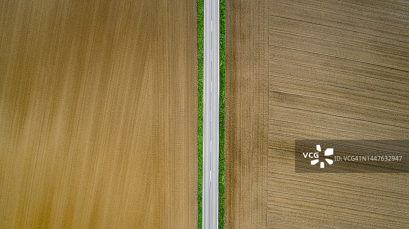 穿过空旷农田的笔直道路图片素材