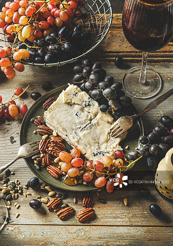 蓝纹戈贡佐拉奶酪配葡萄、蜂蜜、坚果和红酒图片素材