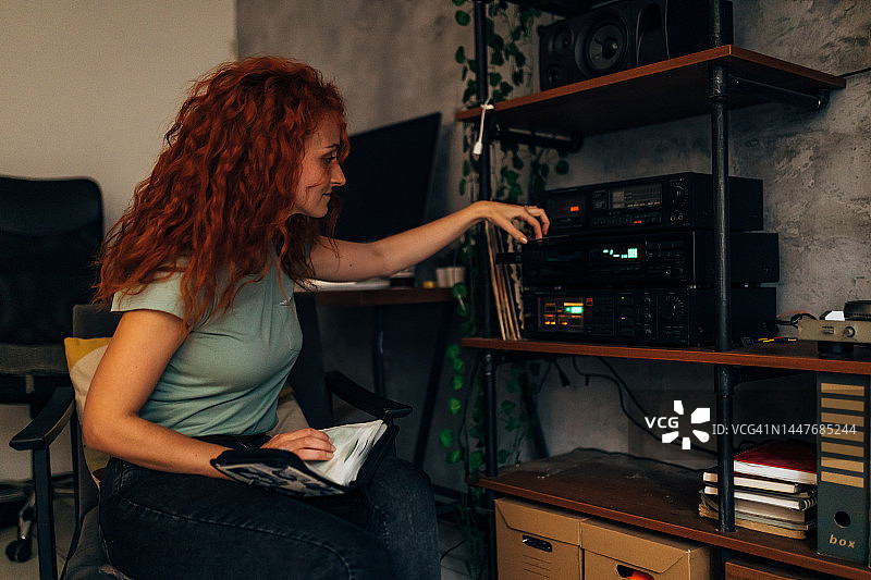 微笑的千禧一代女性听着旧音乐CD图片素材