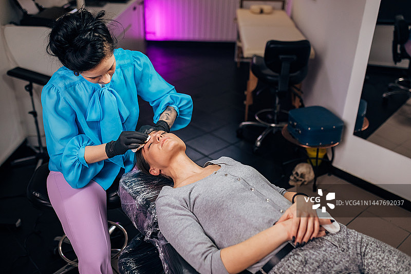 美容师为女人完成面部永久彩妆图片素材