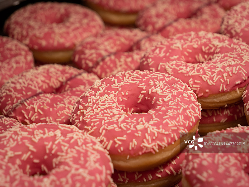 粉色甜甜圈：当地超市烘焙部新鲜出炉的甜点图片素材