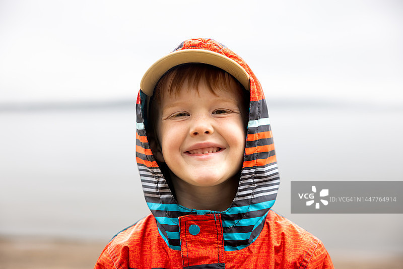 微笑的6岁红发男孩徒步旅行时看着镜头图片素材