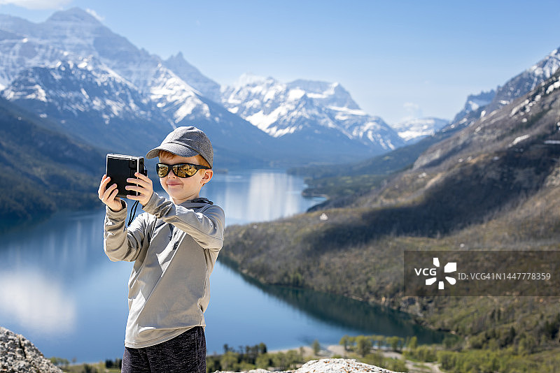 在加拿大沃特顿湖国家公园熊峰步道顶端自拍的红发小男孩图片素材