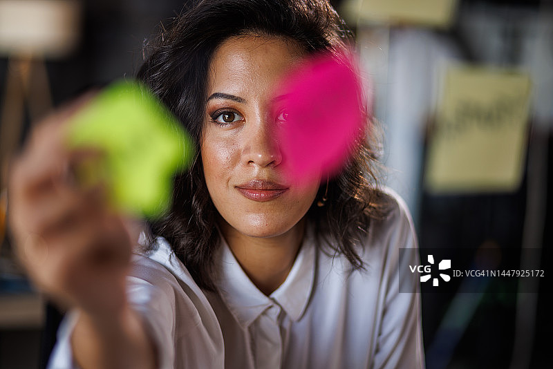 女商人将带有想法的便签贴在玻璃墙上图片素材